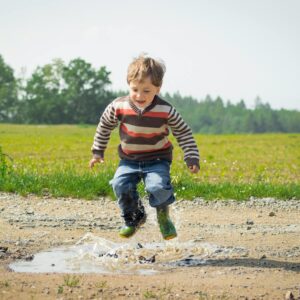 Boy jumping near grass