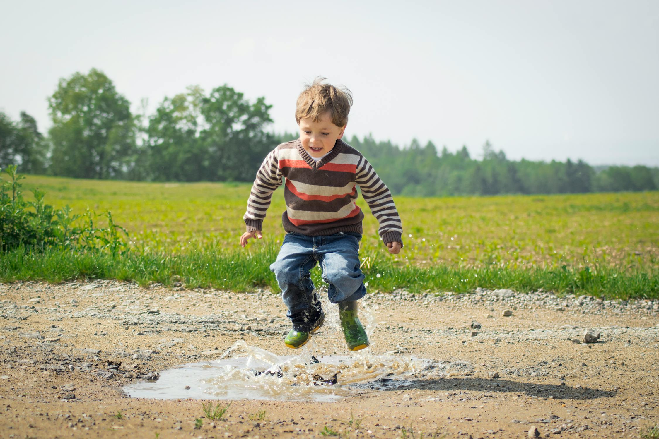 Boy jumping near grass